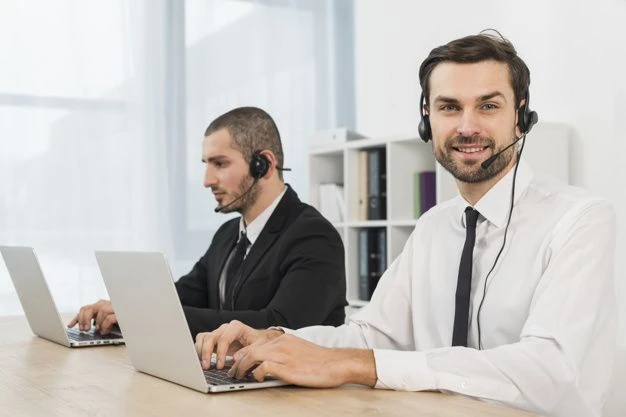 Disponenten eines Busunternehmens mit Headsets bei der Arbeit